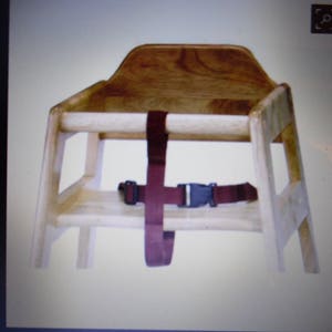 Puede incluir: Una trona de madera de color claro con un acabado de veta natural suave. La silla incluye un respaldo resistente, reposabrazos laterales y una barra de seguridad frontal. Una correa de nailon color granate oscuro con hebilla de pl&aacute;stico negro.