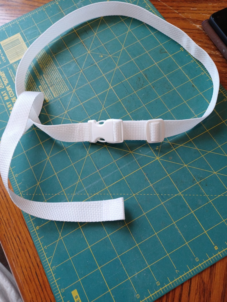 Puede incluir: Un cintur&oacute;n de correa tejida blanca con una hebilla de pl&aacute;stico de liberaci&oacute;n lateral y una hebilla deslizante ajustable. El cintur&oacute;n est&aacute; fabricado con un material de tela texturizada duradera e incluye un extremo suelto para el ajuste.
