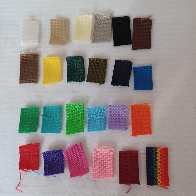 Puede incluir: Una colecci&oacute;n de veinticuatro muestras de tela rectangulares dispuestas en cuatro filas. Las muestras presentan una variedad de colores s&oacute;lidos que incluyen blanco, beige, negro, marr&oacute;n, amarillo, verde, azul, morado, naranja, rojo, rosa y un patr&oacute;n de rayas arco&iacute;ris.