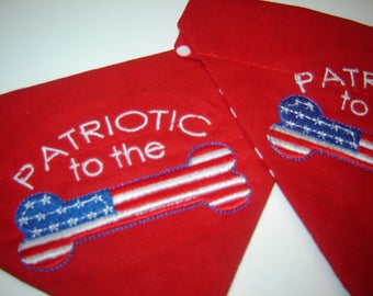 May include: Two red fabric dog bandanas with white embroidered text and an American flag design. The bandanas say "Patriotic to the" and "Patriotic to the".