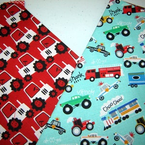 May include: Two fabric squares with different patterns. One square is red with a white and black repeating pattern of tractors. The other square is turquoise blue with a repeating pattern of various vehicles including a fire truck, police car, ambulance, monster truck, train, and a yellow school bus. The text "honk", "VROOM", "ah-oo-ga", "Choo Choo!" and "BEEP!" is written on the turquoise blue fabric.