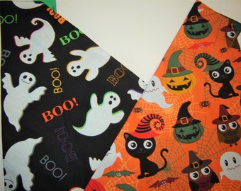 May include: Two fabric panels with Halloween-themed prints. One panel is black with white ghosts and the words "BOO!" in orange and green. The other panel is orange with black cats, owls, pumpkins, and bats. The panels are sewn together at the top.