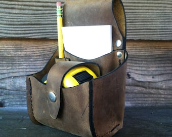 The Cut List- Tape Bag with pockets for pencil and notepad, and adjustable snap flap keeps your measuring tape in place.