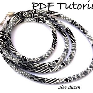 May include: A black and white beaded necklace with a geometric pattern. The necklace is made of small beads and is layered in a triple strand design. The necklace is on a white background. PDF Tutorial.