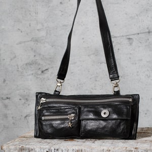 Manchas defectuosas en los clips Mochila bandolera de cuero negra