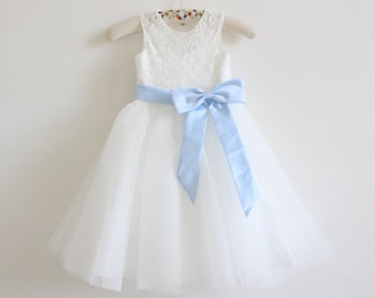 May include: White tulle dress with a lace bodice and a light blue satin bow.