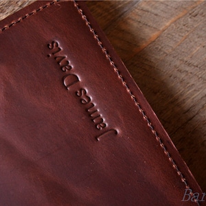 May include: A close-up of a brown leather journal with the name "James Davis" embossed on the front cover.