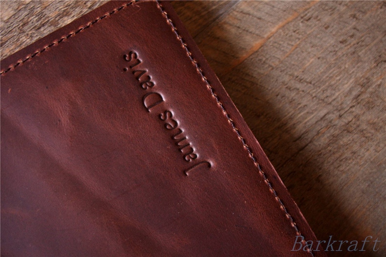May include: A close-up of a brown leather journal with the name "James Davis" embossed on the front cover.