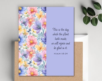 May include: A greeting card with a floral pattern on the left side and a light purple background on the right side. The text on the card reads "This is the day which the Lord hath made; we will rejoice and be glad in it. PSALM 118:24".