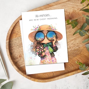 May include: Greeting card featuring an illustration of a girl wearing a straw hat and sunglasses, holding flowers. The sunglasses reflect a field of flowers. The card reads, "His mercies... are new every morning."