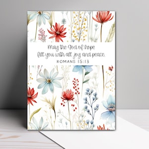 May include: A white background with a floral pattern in shades of red, blue, and green. The text "May the god of hope fill you with all joy and peace. ROMANS 15:13" is printed in black.