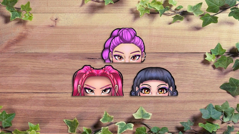Pu&ograve; includere: Tre adesivi con illustrazioni stilizzate di occhi e della parte superiore del viso. Gli adesivi hanno diversi colori di capelli: viola, rosa e blu scuro. Lo sfondo &egrave; una superficie di legno con foglie verdi.