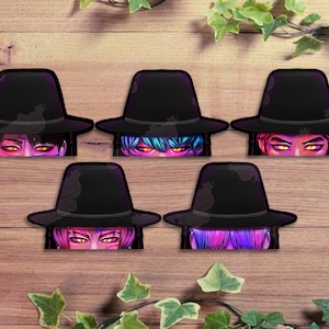 May include: Five stickers featuring a black witch hat with colorful hair and glowing eyes. The stickers are arranged on a wooden surface with green ivy accents, creating a spooky, Halloween theme.
