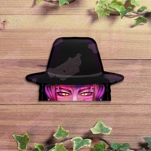May include: A black fedora-style hat with a purple brim and a decorative pattern. The hat partially obscures a face with pink hair and glowing yellow eyes. The image is set against a wooden background with green ivy.