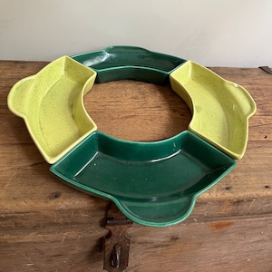 May include: A set of four ceramic serving dishes in a circular shape. The dishes are green and yellow with a speckled glaze. The dishes are perfect for serving snacks, dips, or appetizers.