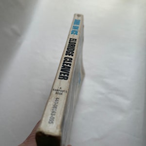 May include: A white book with the title "Soul on Ice" by Eldridge Cleaver, a Ramparts Book, with the ISBN 440-08163-095.