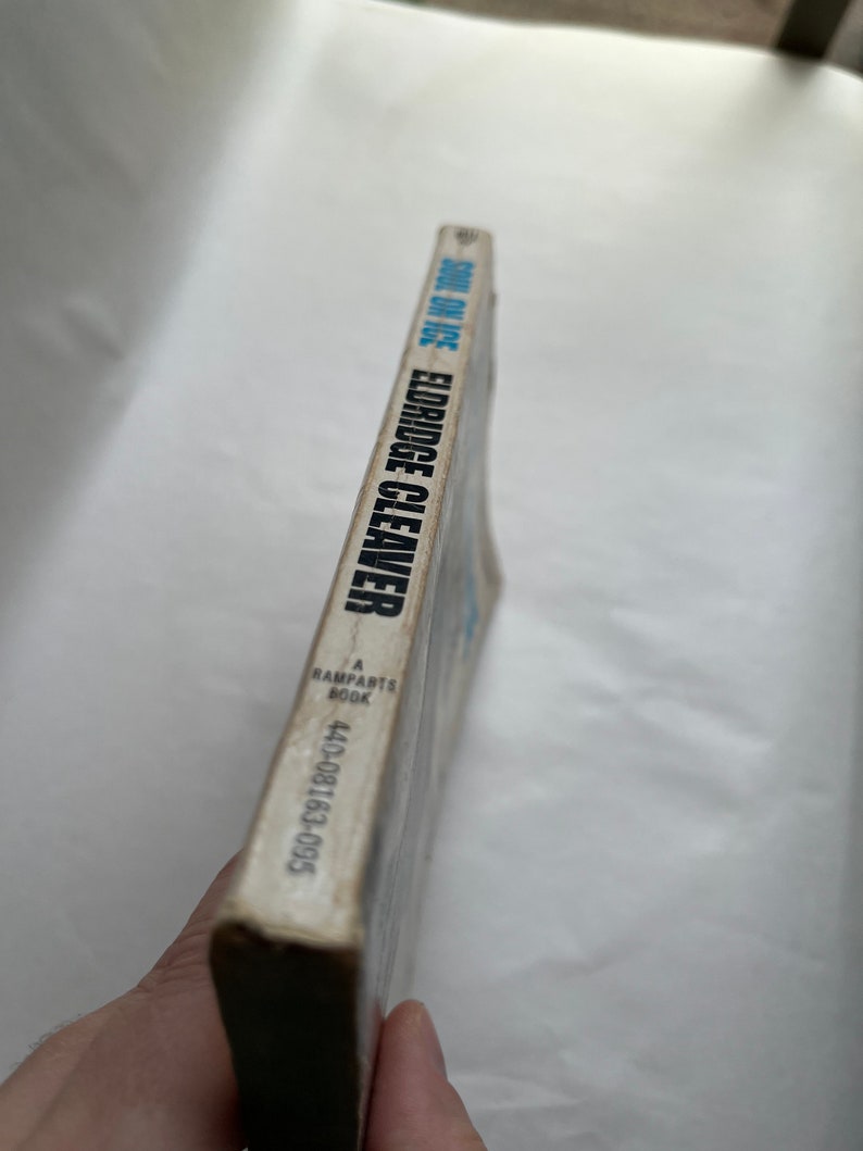 May include: A white book with the title "Soul on Ice" by Eldridge Cleaver, a Ramparts Book, with the ISBN 440-08163-095.