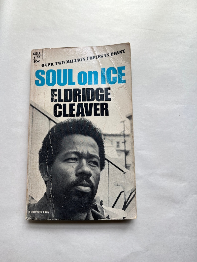 May include: A paperback book cover with a black and white photo of a man with a beard. The title of the book is "Soul on Ice" by Eldridge Cleaver. The book cover also includes the text "Over Two Million Copies in Print".
