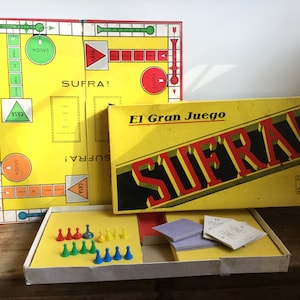 May include: A vintage board game called "Sufra!" in a yellow box with black and red lettering. The game board is yellow with green and red accents. The box includes game pieces, cards, and instructions.