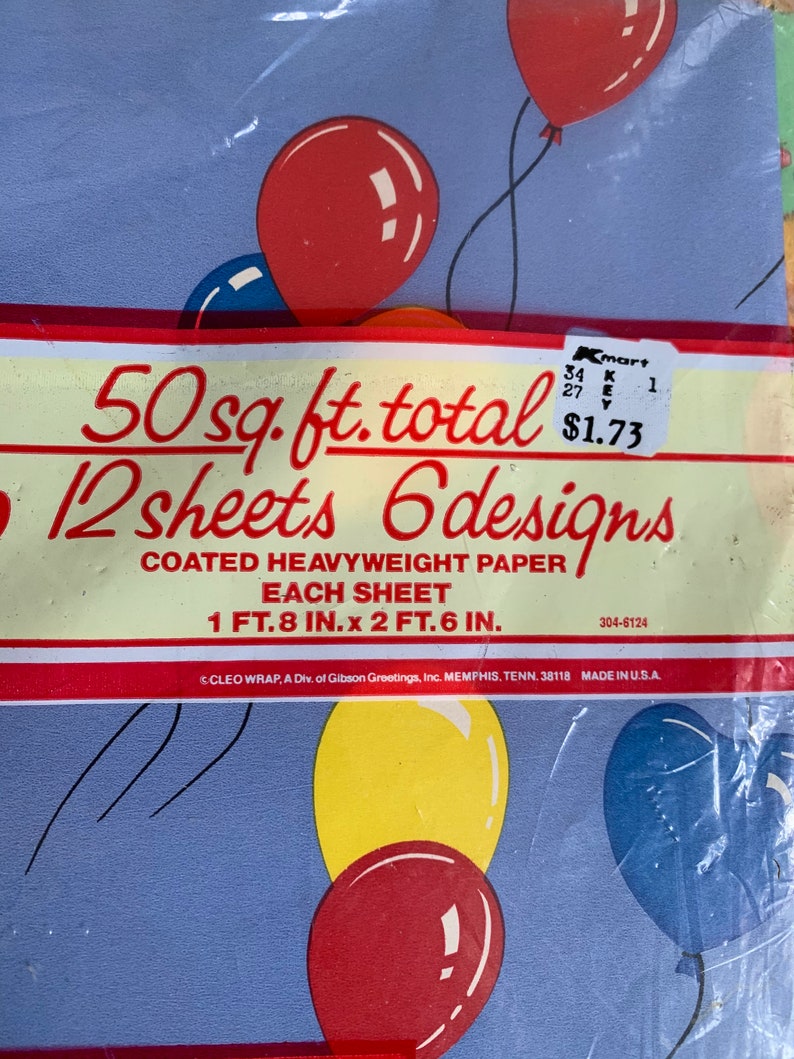 May include: A pack of 12 sheets of blue, yellow, and red balloon patterned wrapping paper. The pack says "50 sq. ft. total 12 sheets 6 designs" and "COATED HEAVYWEIGHT PAPER EACH SHEET 1 FT. 8 IN. x 2 FT. 6 IN."