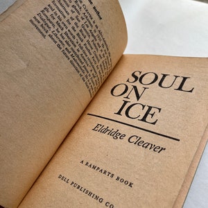 May include: A vintage paperback book titled "Soul on Ice" by Eldridge Cleaver. The book is a Ramparts Book published by Dell Publishing Co., Inc.