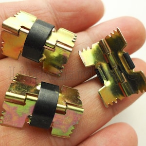 Puede incluir: Tres clips metálicos de color dorado con inserciones de goma negra. Los clips tienen un borde dentado y una bisagra.