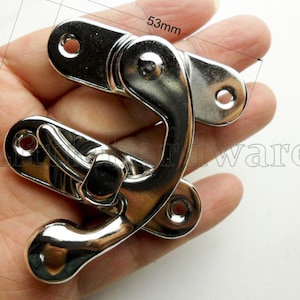 May include: Silver-toned metal latch with a hook and a loop. The latch measures 2.48 inches in length and 1.97 inches in width.