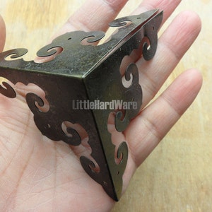 Puede incluir: Soporte de esquina de latón antiguo con un diseño decorativo de desplazamiento. El soporte tiene aproximadamente 7,5 cm de ancho y tiene un acabado desgastado.