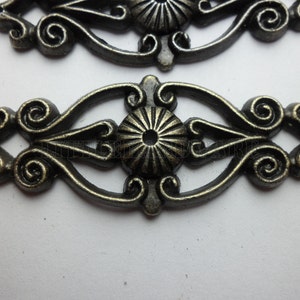 Puede incluir: Herrajes decorativos de metal de estilo antiguo en acabado bronce. Los herrajes presentan un diseño central de rayos de sol con volutas y detalles decorativos. Ideal para la restauración de muebles o proyectos de artesanía.