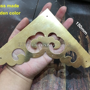 May include: A brass-made, golden-colored corner bracket with decorative cutouts. The bracket is triangular, with a length of 150mm. The text "LITTLEHARDWARE" is visible. The text "brass made golden color" is also visible.