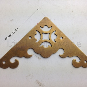 May include: Brass corner bracket with a decorative, intricate design. The bracket is 2.2 inches in size.