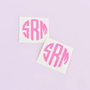 May include: Two square white adhesive decals featuring a bright pink circular monogram design with the letters SRM in a bold, block-style font. The circular border has a scalloped edge, and the letters are centered within the pink circular shape.
