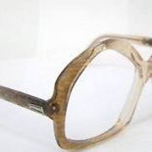 Puede incluir: Un par de gafas vintage, de gran tamaño, de plástico transparente con un patrón de carey. Las monturas tienen una forma geométrica única.