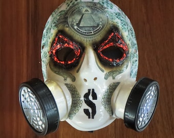 May include: A white gas mask with a dollar sign on the front. The mask has a green and white pattern and red glowing eyes. The mask is attached to two black filters.