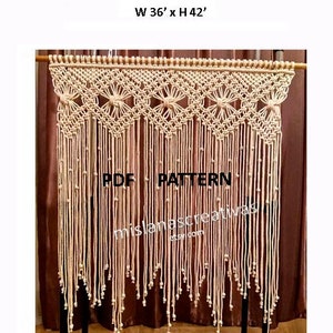 May include: A handmade macrame curtain with a geometric pattern, measuring 36 inches wide by 42 inches tall. The curtain is made with natural colored cord and features a fringe at the bottom.