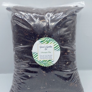 Könnte beinhalten: Ein klarer Plastikbeutel gefüllt mit dunkelbrauner Blumenerde. Ein rundes Etikett auf dem Beutel trägt die Aufschrift "Grace's Garden Co Ultimate Mix" mit einer Zutatenliste. Die Mischung enthält Kokosfasern, Kokoschips, Kiefernrindenfein, Perlit, Bimsstein, Holzkohle und Wurmkot.