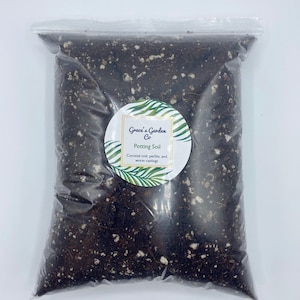 May include: A clear plastic bag filled with dark brown potting soil. The bag has a white label with the text "Grace's Garden Co Potting Soil Coconut coir, perlite, and worm castings."