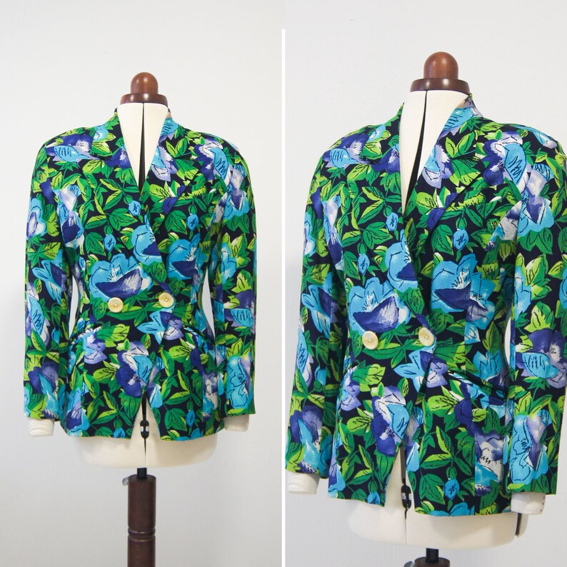 May include: A double-breasted blazer with a vibrant floral print featuring blue, green, and white flowers on a black background.