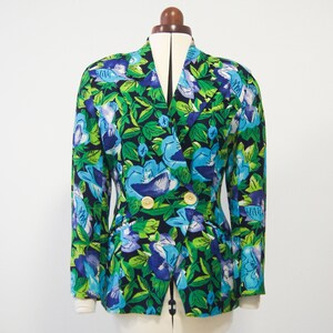 May include: A double-breasted blazer with a vibrant floral print featuring blue, green, and purple flowers on a black background.