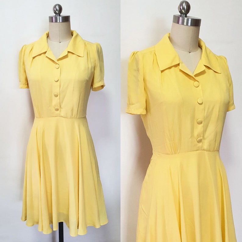May include: A yellow short-sleeved dress with a collared neckline and button closure. The dress has a fitted bodice and a flared skirt.