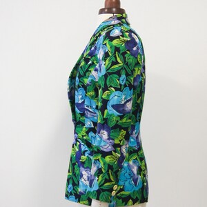 May include: A black blazer with a floral print featuring blue and green flowers on a dark background.