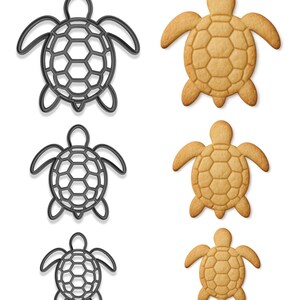 May include: Image features three turtle-shaped cookie cutters in varying sizes next to three turtle-shaped cookies. The cookie cutters are dark gray, with a honeycomb pattern on the shell. The cookies are golden brown with a textured shell design.