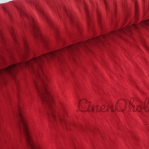 May include: Close-up of a red linen fabric with a textured, woven appearance. The fabric is folded in half, creating a soft, draping effect. The text "LinenOhollic" is visible in the lower right corner of the image.