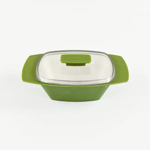 May include: A green plastic container with a clear lid. The container has a square shape with rounded corners and a small handle on the lid.