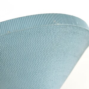 May include: Close-up of a light blue, textured bowl. The bowl has a woven pattern on the sides and a ribbed rim. The bowl is set against a white background.
