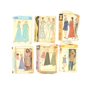 May include: Six vintage sewing patterns for women's clothing. The patterns are from Simplicity and McCall's. The patterns include a long dress, a skirt and top, a dress with a skirt, a dress with a long sleeve, and a dress with a short sleeve.