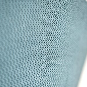 May include: Close-up of a light blue, textured surface with a repeating geometric pattern. The pattern appears to be a series of small, raised triangles, creating a subtle, three-dimensional effect. The surface curves slightly, suggesting a cylindrical or rounded shape.