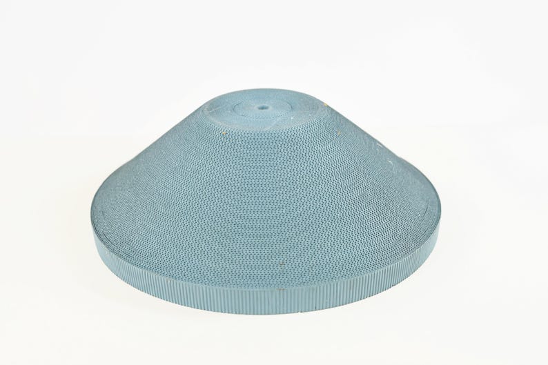 May include: A light blue, cone-shaped object with a textured surface and a small hole at the top. The object has a wide, flat base and a rounded top. The material appears to be a type of paper or cardboard.