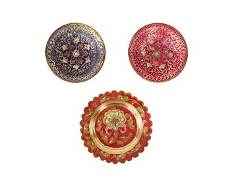 May include: Three decorative plates with intricate floral designs. The plates are made of brass and have a gold finish. The designs are in shades of red, blue, and gold.