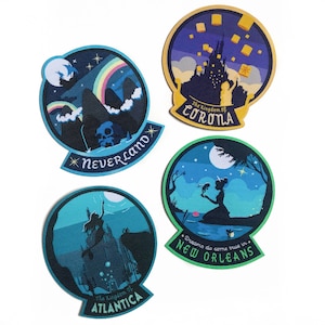 May include: Four round, colourful patches with embroidered designs and text. The patches feature scenes from the movies: *Neverland*, *The Kingdom of Corona*, *New Orleans*, and *The Kingdom of Atlantica*.